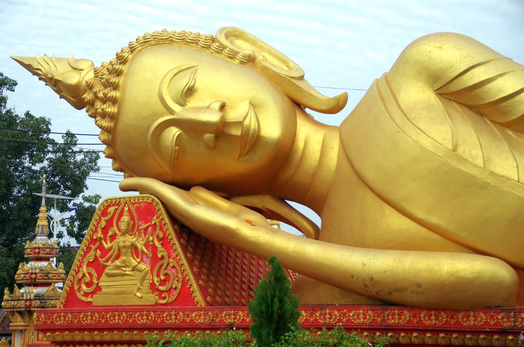 Enorme Buddha dorato sdraiato accanto al complesso Pha That Luang di Vientiane, viaggio organizzato in Laos