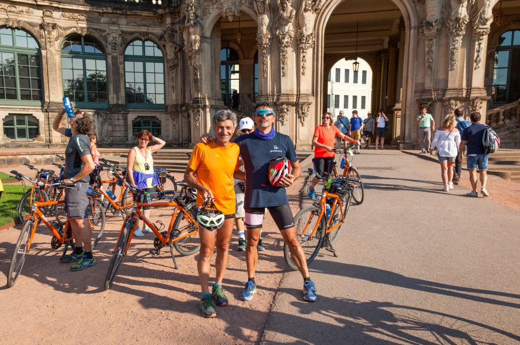 Cicloturisti all'entrata dello Zwinger, monumento barocco della città tedesca di Dresda, Germania