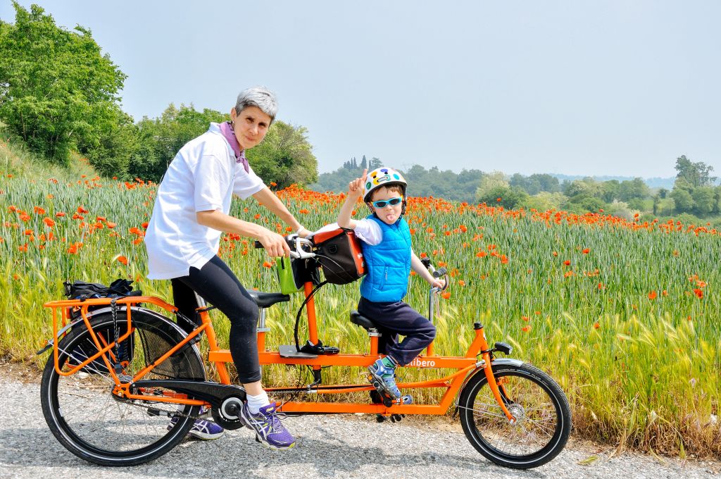 Famiglia in tandem "Girolibero" lungo un percorso di campagna vicino al Lago di Garda