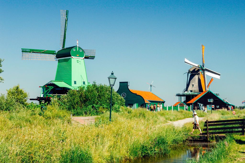 Traditional windmills surrounded by fields and waterways in Kinderdijk, Netherlands.