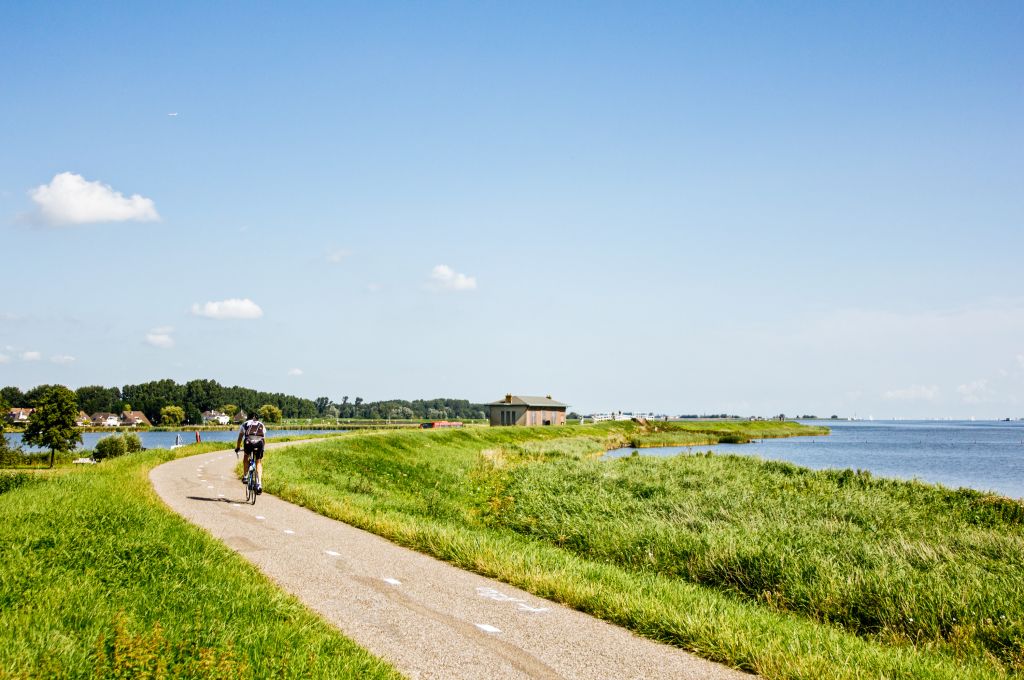 Ciclista su sentiero lungo la costa verde nell'Olanda settentrionale, escursioni in bici, Isole Frisone, viaggi in bici e barca "Girolibero"