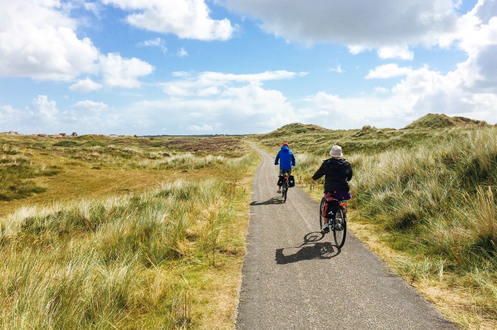 Ciclisti su un sentiero tra le dune sabbiose sulla costa olandese.