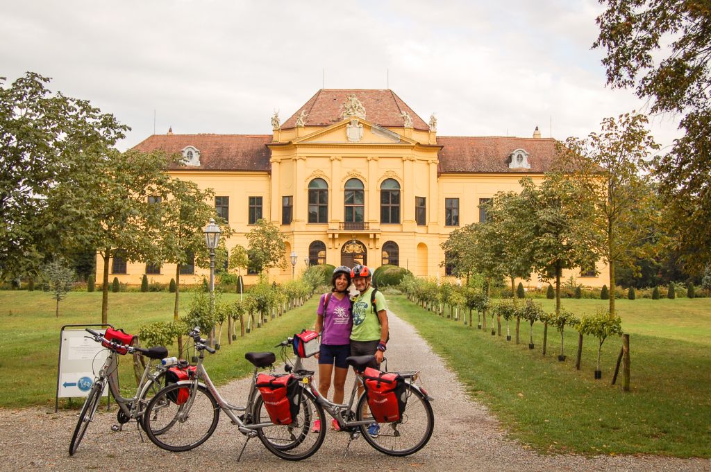 Ciclisti fermi nei giardini con vista sulla facciata dell'Abbazia di Melk, Austria