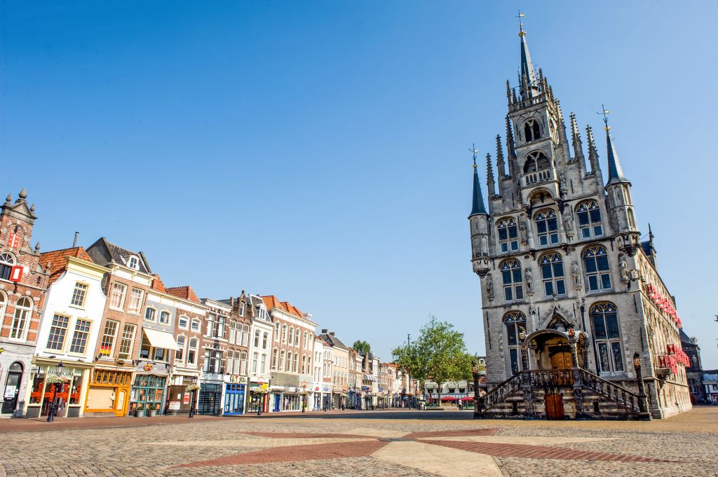 Historische gotische Kirche mit traditionellen Häusern im Zentrum von Delft, Niederlande.
