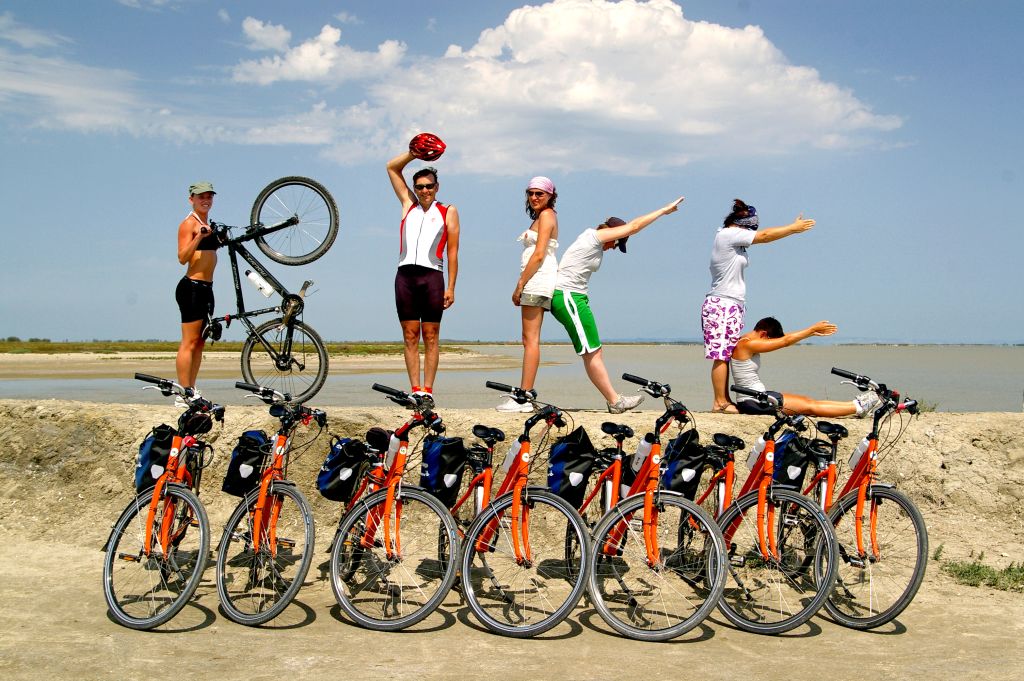 Menschen posieren am Strand mit Fahrrädern, Küstenradtour.