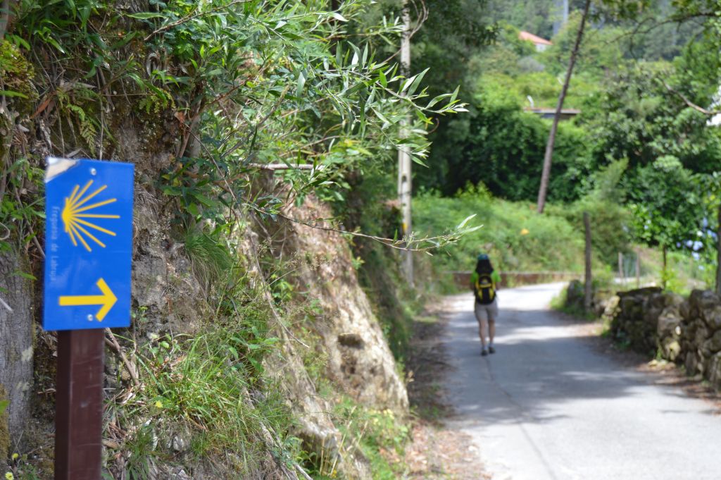 Freccia blu su un muro lungo il Cammino Portoghese di Santiago, indicazione tipica per i pellegrini.