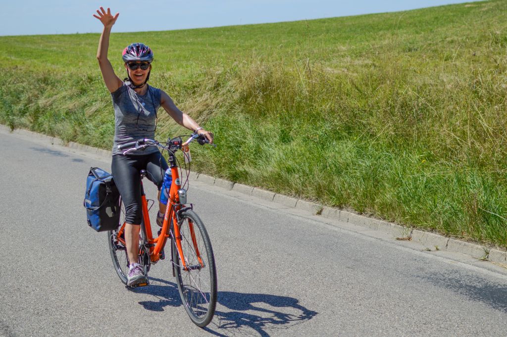 Ciclista su strada di campagna in Germania, viaggio in bici tra colline e prati.