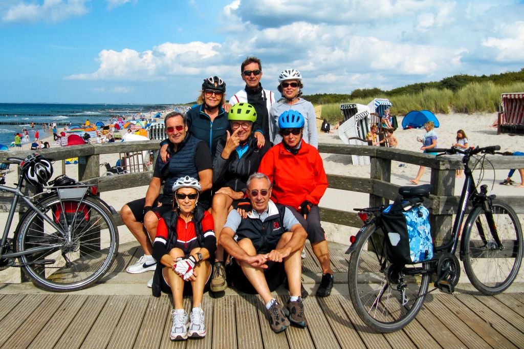 Gruppo di ciclisti si ferma per una pausa su una passerella con vista sul mare Baltico, vacanze di gruppo in bici "Girolibero"