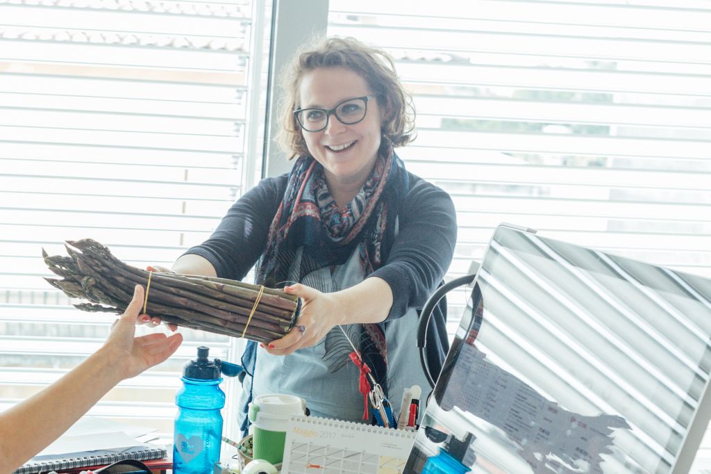 Staff Girolibero con in mano degli asparagi acquistati da un produttore locale