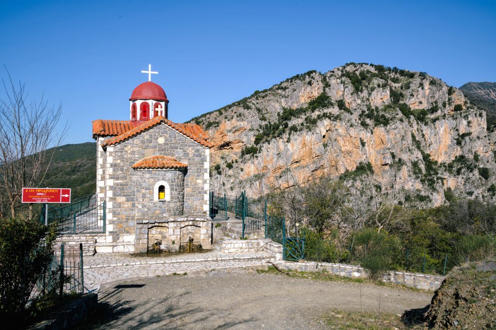 Chiesa ortodossa con cupola rossa su una collina rocciosa
