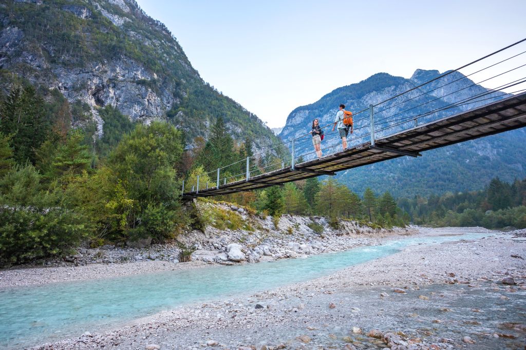 Ponte sospeso sopra il fiume Isonzo nel Parco del Triglav, Slovenia, con paesaggio alpino.