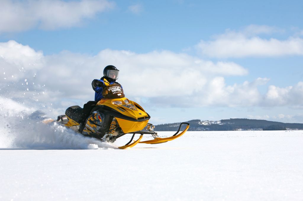 Persona che guida una motoslitta su un paesaggio innevato in Lapponia, Finlandia.
