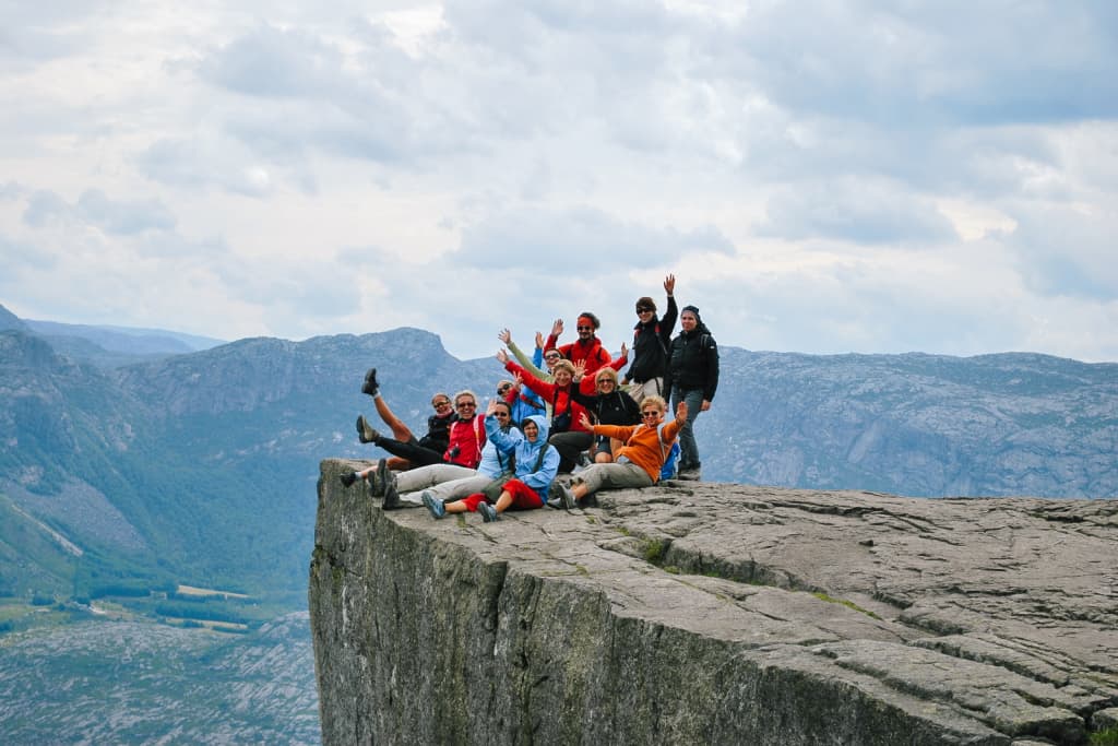 Gruppo di escursionisti in vacanza con Girolibero sulla scogliera di Preikestolen con vista panoramica sul Lysefjord, Norvegia.