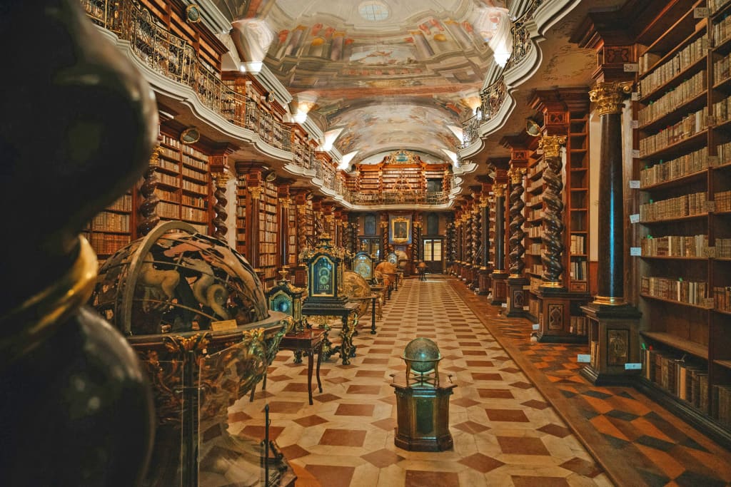 Biblioteca barocca del Klementinum di Praga con scaffali lignei, globi e affreschi, tesoro culturale ceco