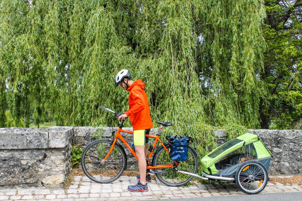 Father biking with his child in french rural landscape, cycling holidays Girolibero