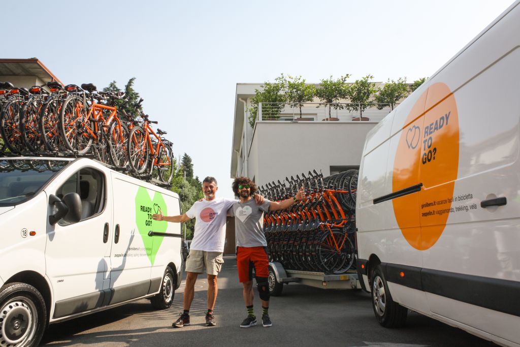 Loading bicycles onto a white Girolibero van for transport