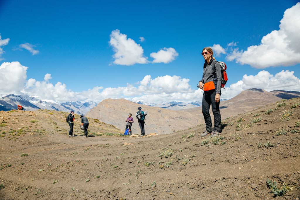 Gruppo di trekking in cammino tra i paesaggi dell'India, sotto un cielo azzurro.