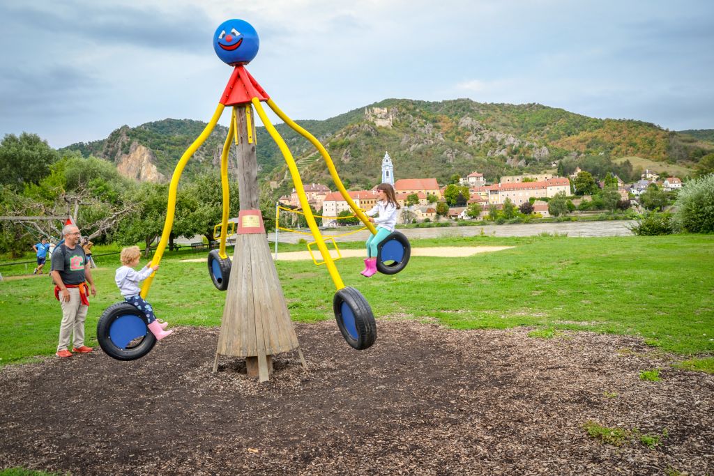 Giostra in un parco giochi lungo la ciclabile del Danubio, vacanza in bici per famiglie, tempo libero, Austria