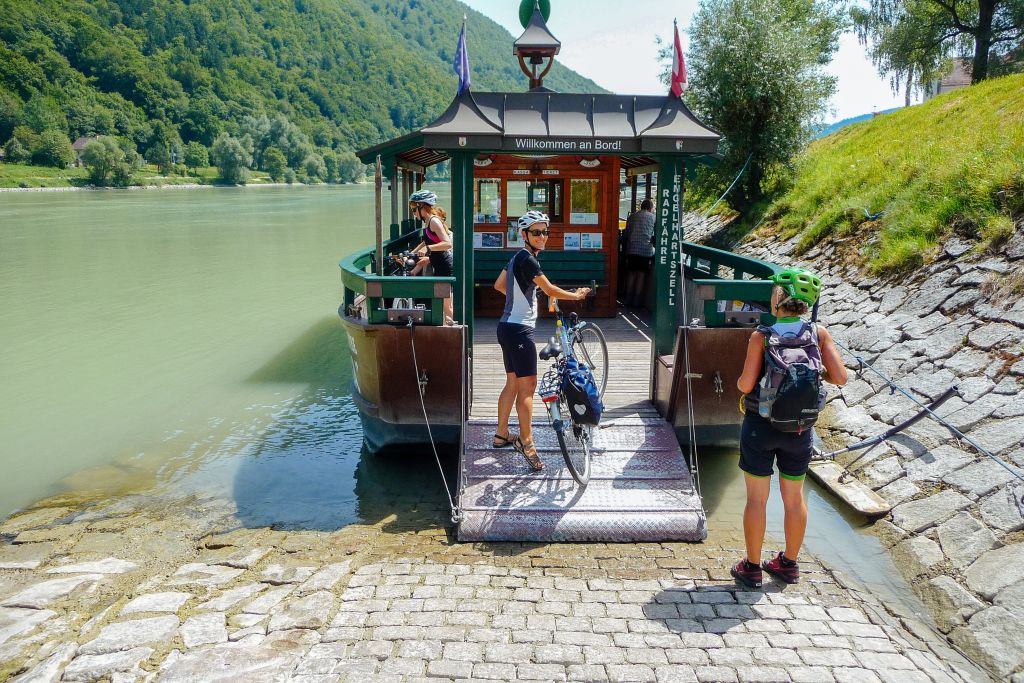 Cicloturisti intenti a salire su un'imbarcazione per attraversare fiume Danubio, ciclabile tra Passau e Vienna, Austria