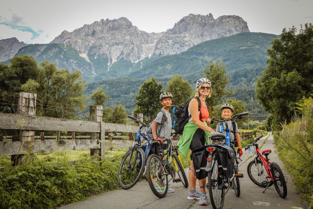 Famiglia di cicloturisti, bambini con caschetto, paesaggio di montagna, vacanza all'aria aperta, Austria