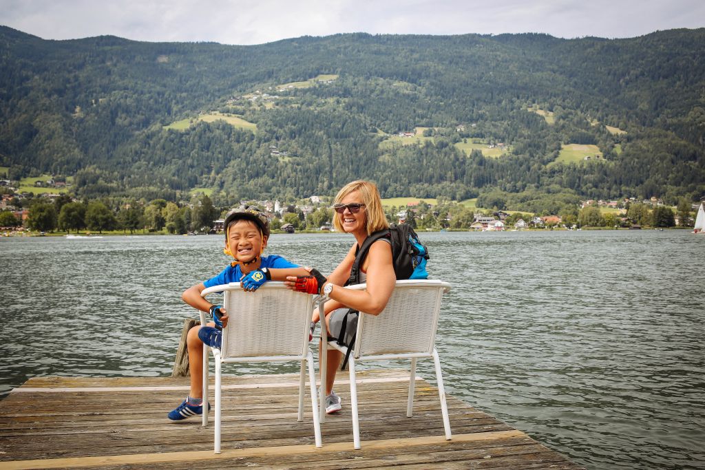 Viaggi per famiglie con Girolibero, escursionisti sorridenti, fiume Drava, paesaggio di montagna, Austria