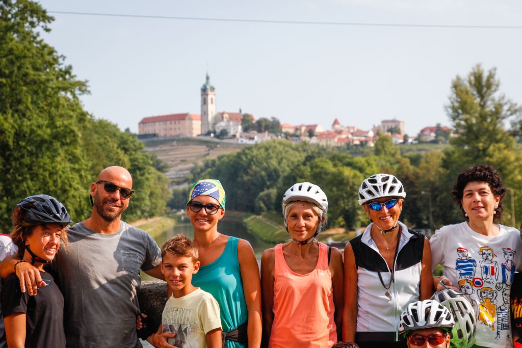 Gruppo di cicloturisti con bambini, ponte, fiume Elba, alberi, vacanza all'aria aperta, paesino tra Dresda e Praga