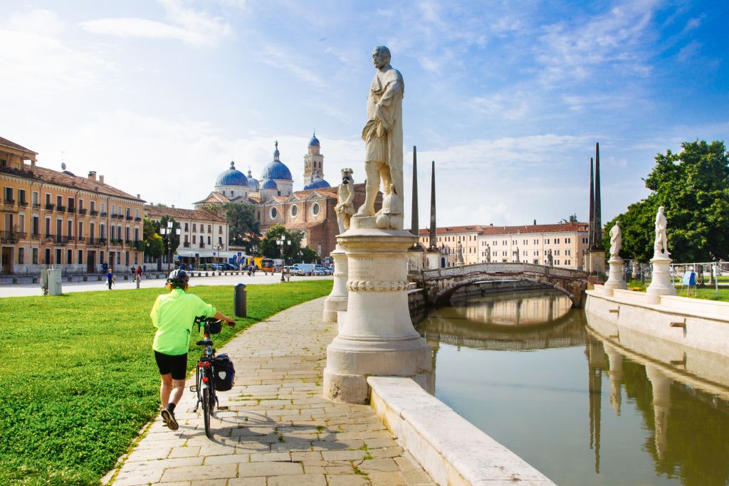 Cicloturista, Prato della Valle, piazza principale della città di Padova, relax, turismo slow in bicicletta, Veneto