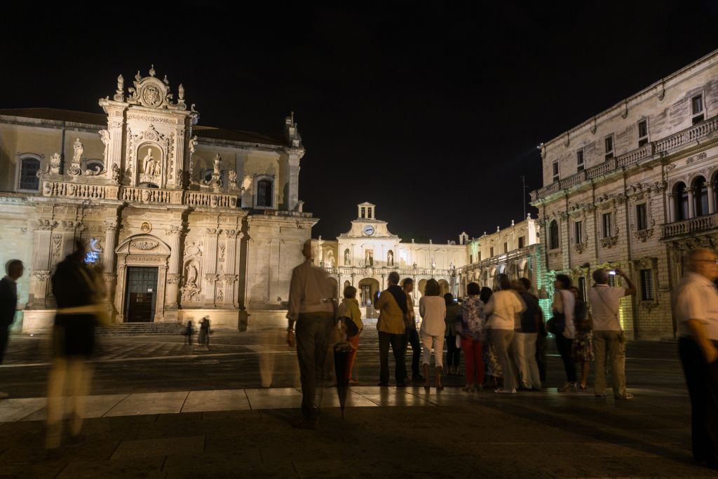Piazza illuminata di notte con la Basilica di Santa Croce a Lecce, Salento.