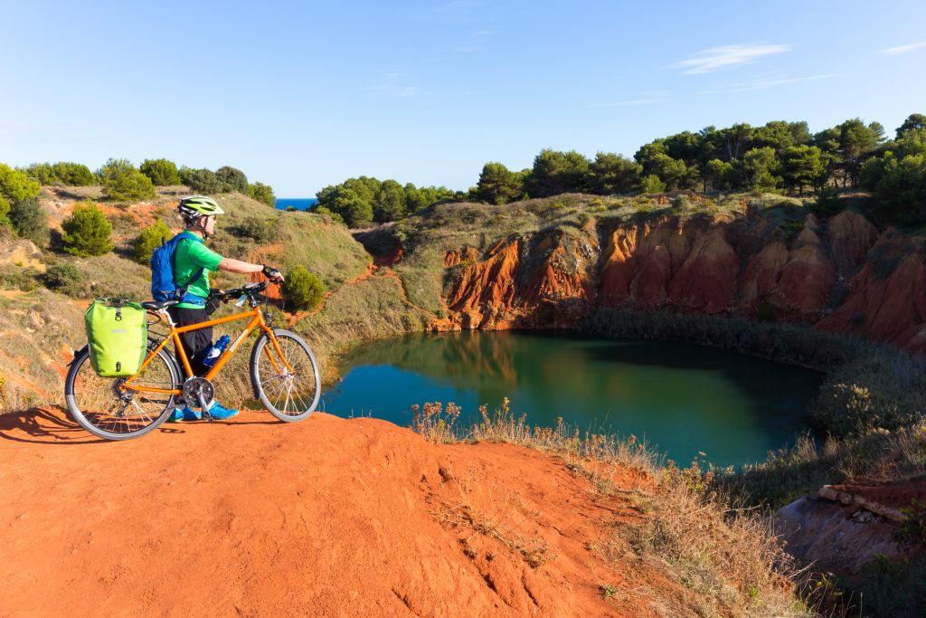 Cyclist stops near the Bauxite lake in Otranto