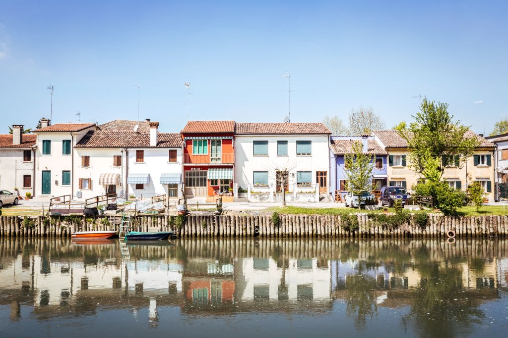 Fila di casette colorate a ridosso del fiume Sile lungo la tappa da Treviso a Mestre, Veneto