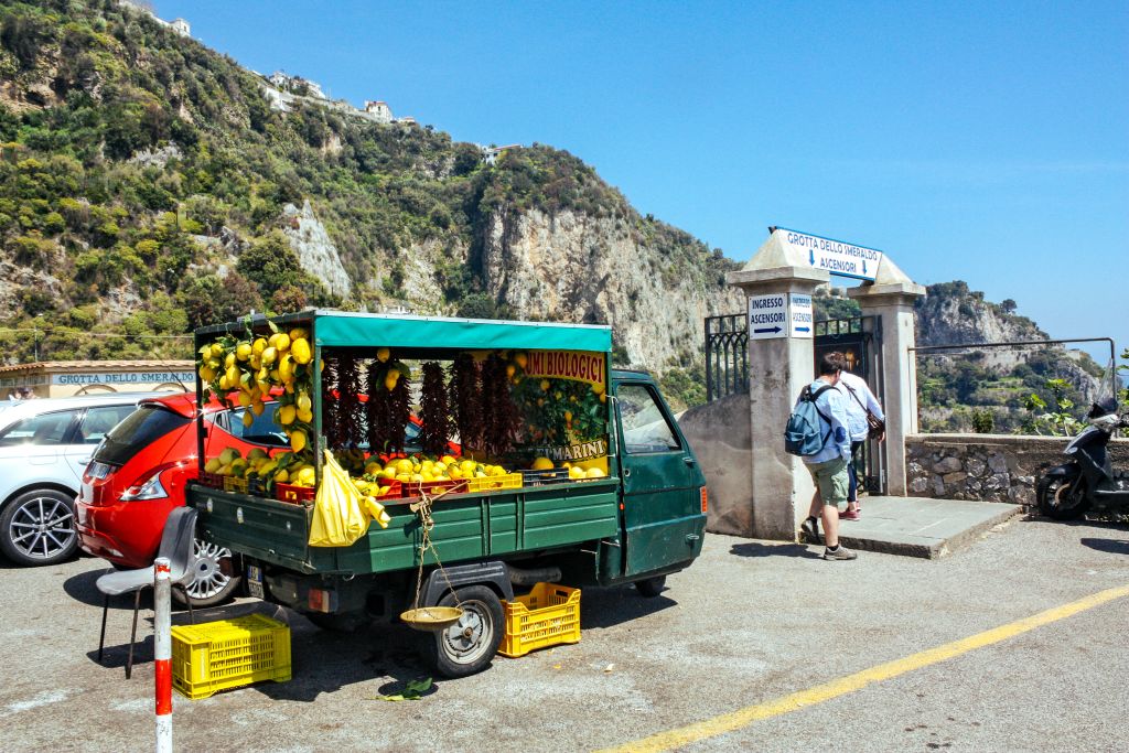 Ape car verde carica di limoni freschi, venditore locale di limoni a bordo strada lungo strada, Costiera Amalfitana
