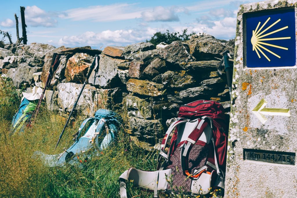 Zaino appoggiato ad un mojon del Cammino con concha gialla