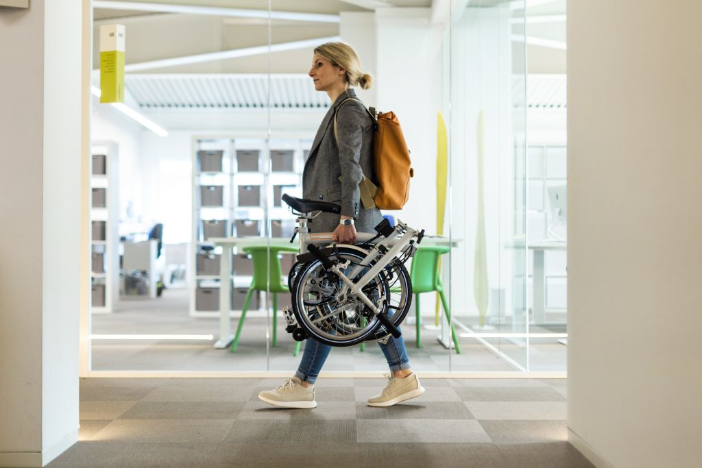 Girolibero-Mitarbeiter trägt ein Fahrrad durch den Hauptsitz