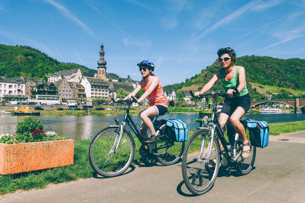 Radfahrer entlang des Moselwegs, durch Weinberge und Hügel, Deutschland.