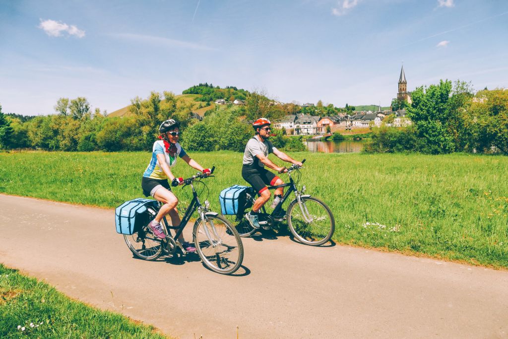 Familie beim Radfahren entlang des Moselradwegs, umgeben von Weinbergen