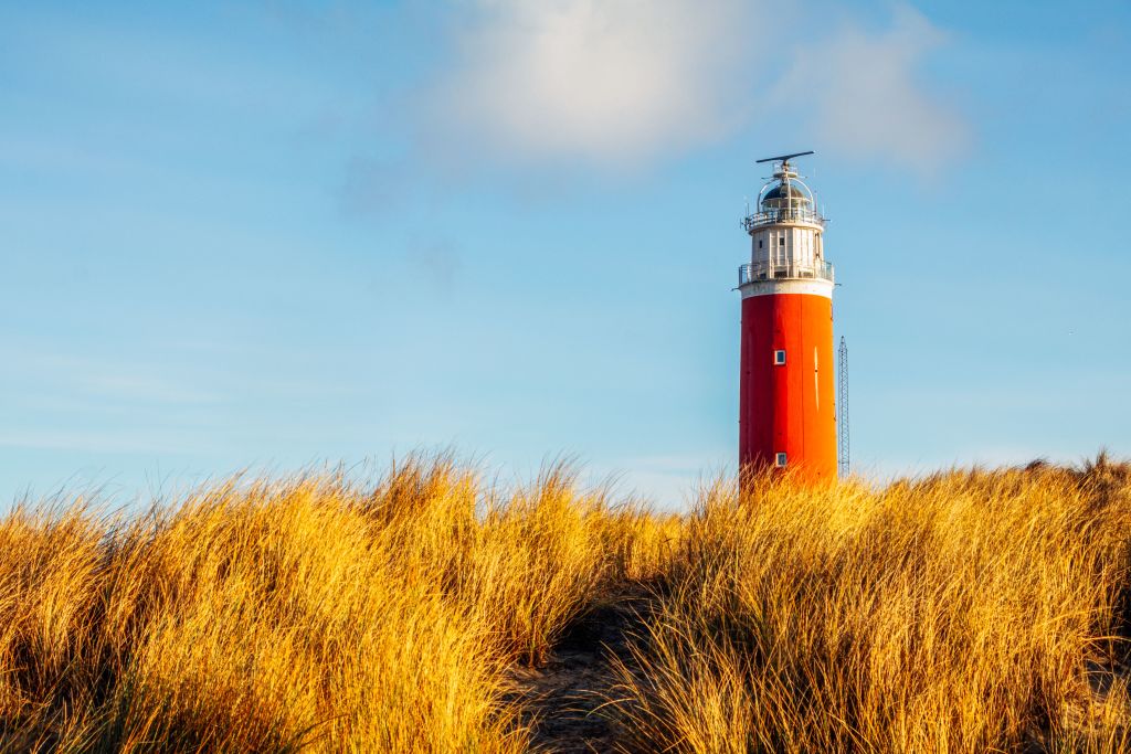 Faro rosso tra le dune sull’isola di Texel, Olanda del Nord.