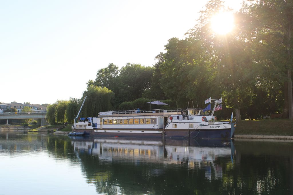 Nave fluviale Zwaantje in navigazione lungo il fiume Saône al tramonto, Borgogna, Francia.