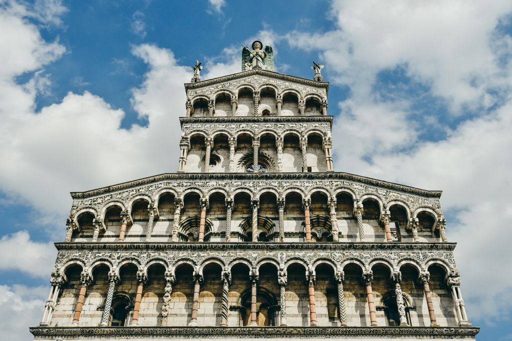 Chiesa di San Michele in Foro con cielo azzurro e nuvole sullo sfondo, Lucca, Toscana.