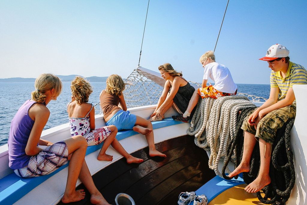 Gruppo di turisti in barca ammira i panorami sull'Adriatico e la costa della Dalmazia, viaggi in bici e barca "Girolibero"