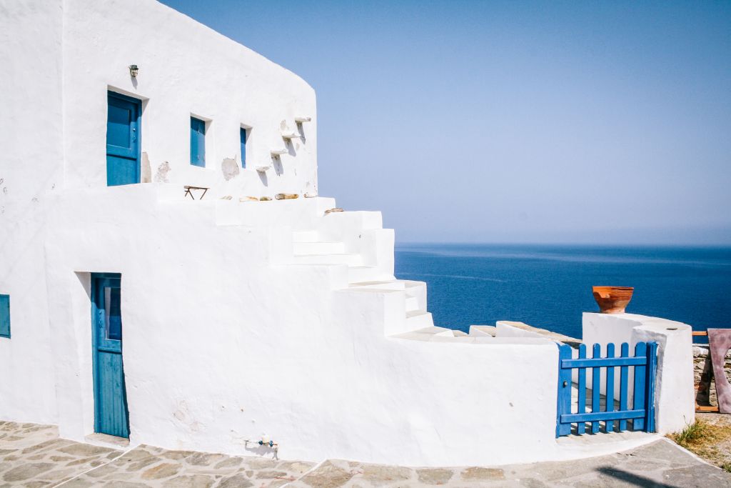 Casa bianca con portone blu tradizionale a Paros, vista sul mare