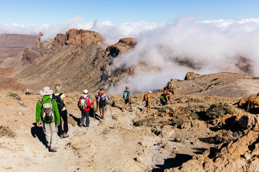 Escursionisti sul cratere del vulcano Teide con fumo, tour Canarie a piedi, viaggi di gruppo organizzati con accompagnatore