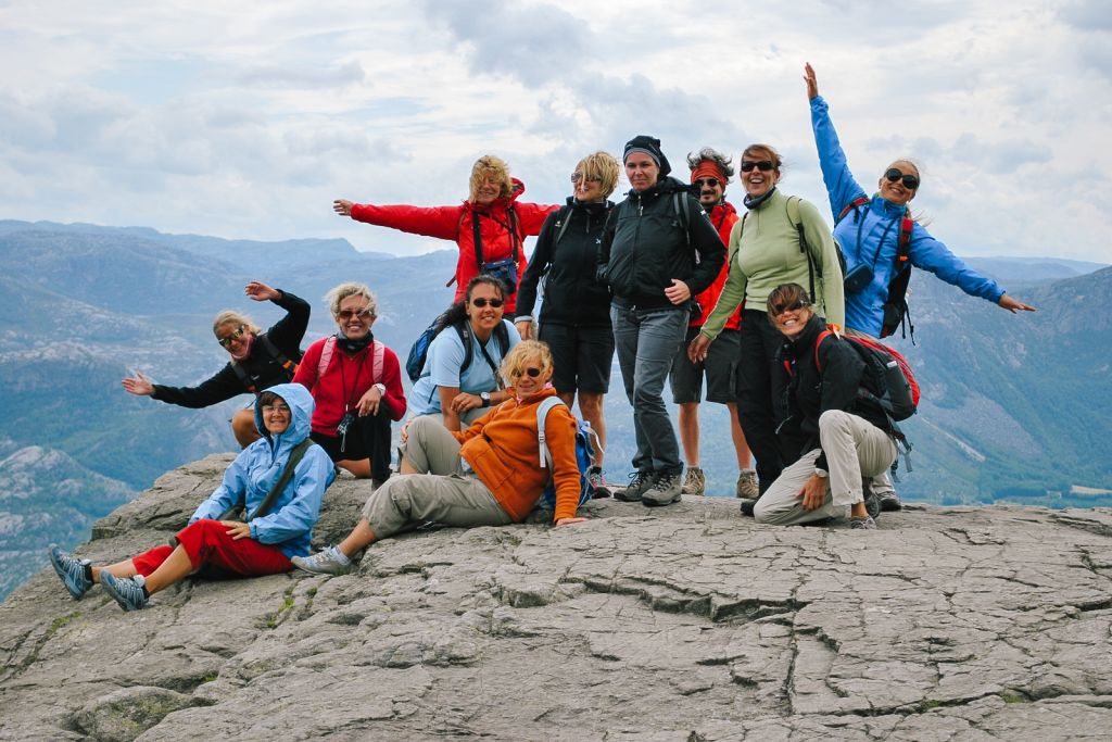 Tour di gruppo con "Girolibero", turisti sorridenti sulla piattaforma panoramica di Preikestolen, Norvegia.