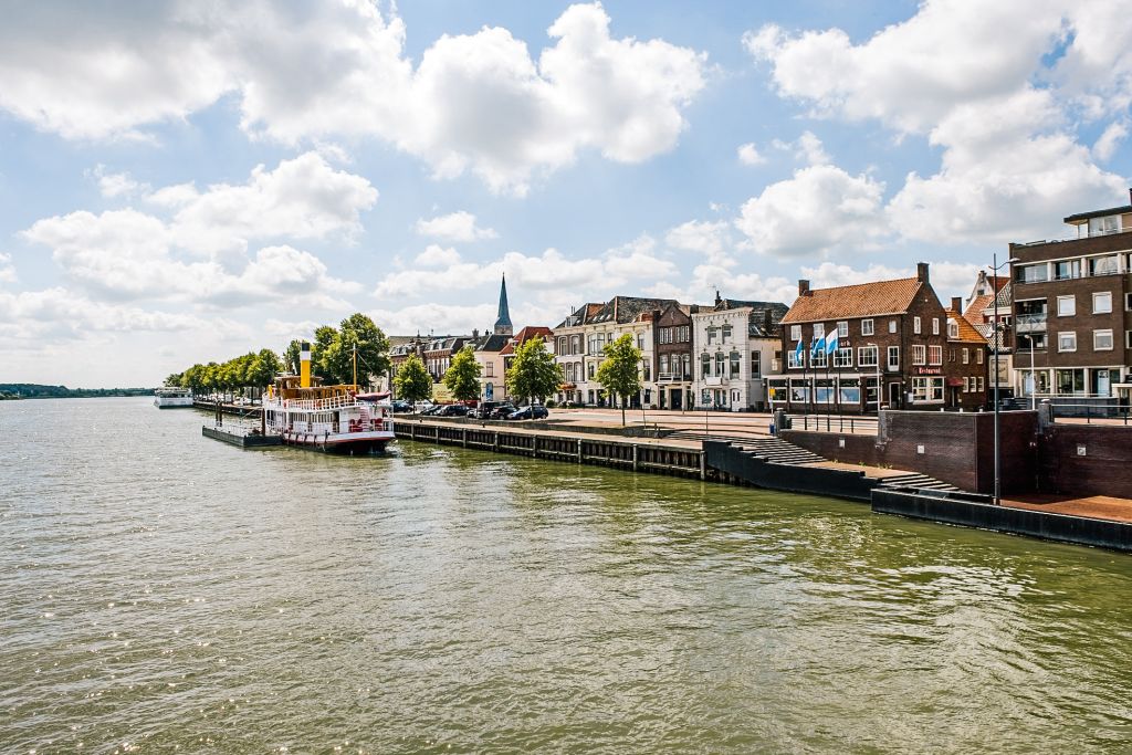 Case storiche tipiche lungo un canale nei Paesi Bassi con cielo nuvoloso.