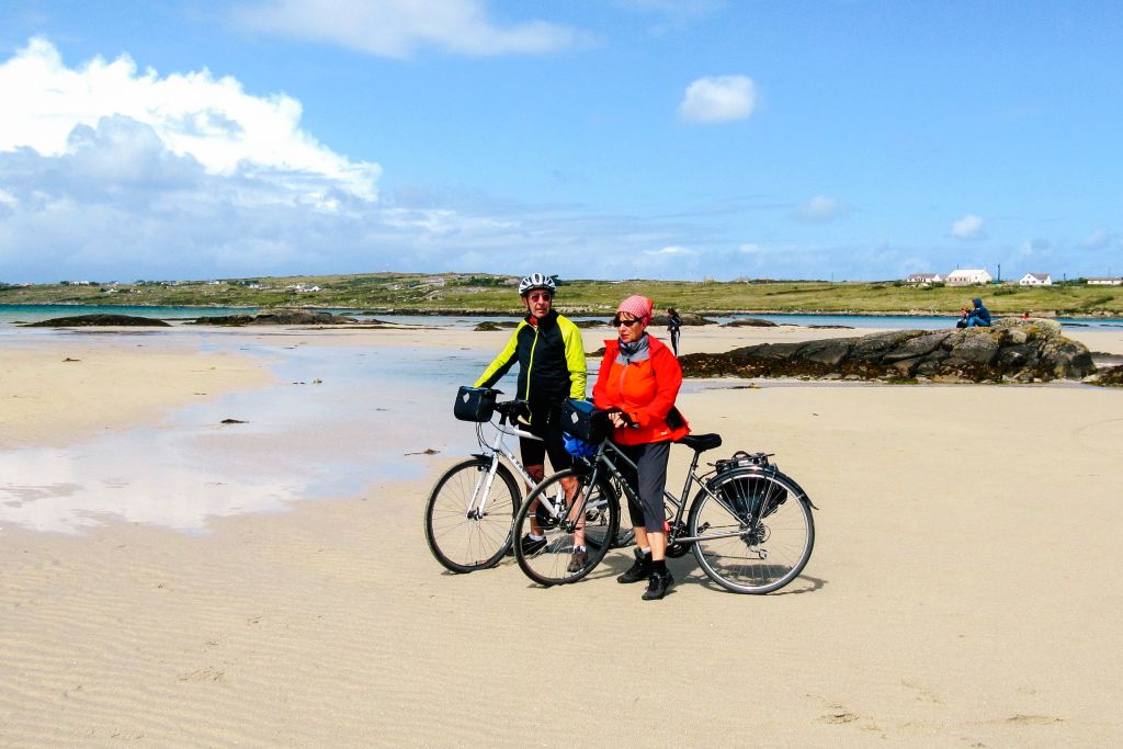 Persone in bicicletta su una spiaggia del Connemara, Irlanda, vacanze in bici con Girolibero.