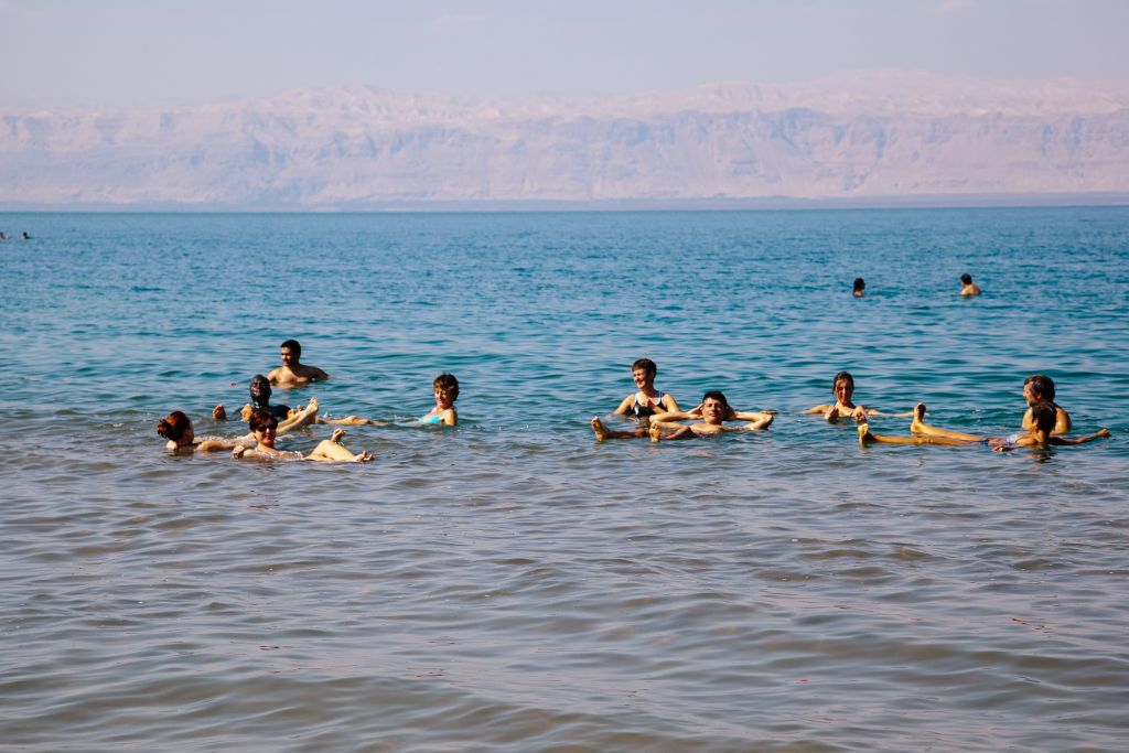 Turisti che fanno un bagno nelle rive del Mar Morto, viaggi in gruppo "Girolibero"