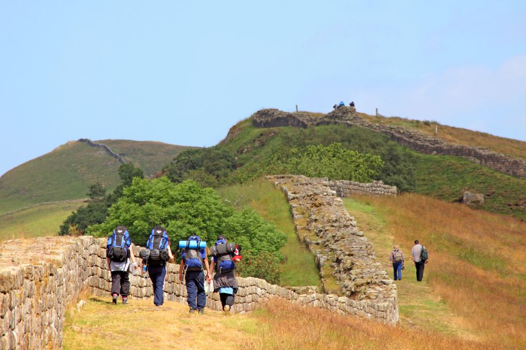 Gruppo di escursionisti che attraversa un prato verde lungo l’Adrian Way.