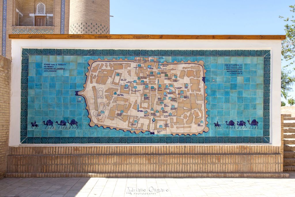 Pannello in piastrelle turchesi con la mappa storica dell’Itchan Kala di Khiva, installazione fotografabile lungo le mura UNESCO durante un tour in Uzbekistan