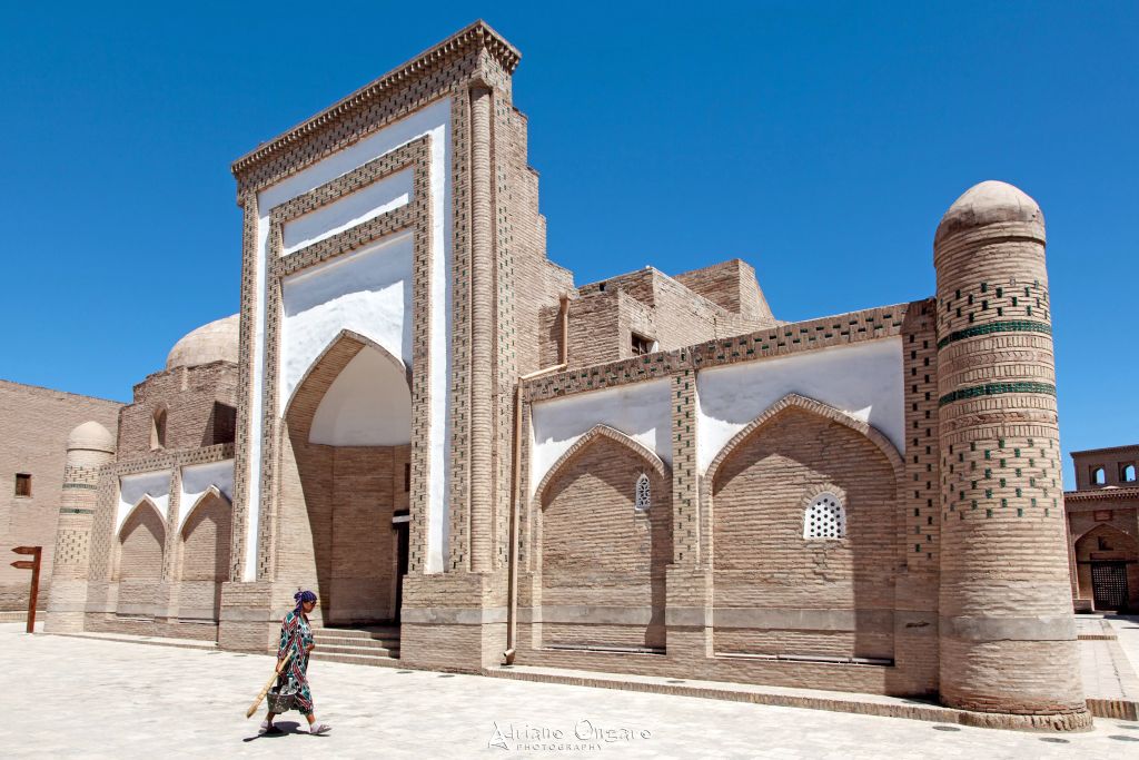 Portale in mattoni e minareto cilindrico di una madrasa storica nell’Itchan Kala di Khiva, tappa UNESCO nel viaggio in Uzbekistan in autunno