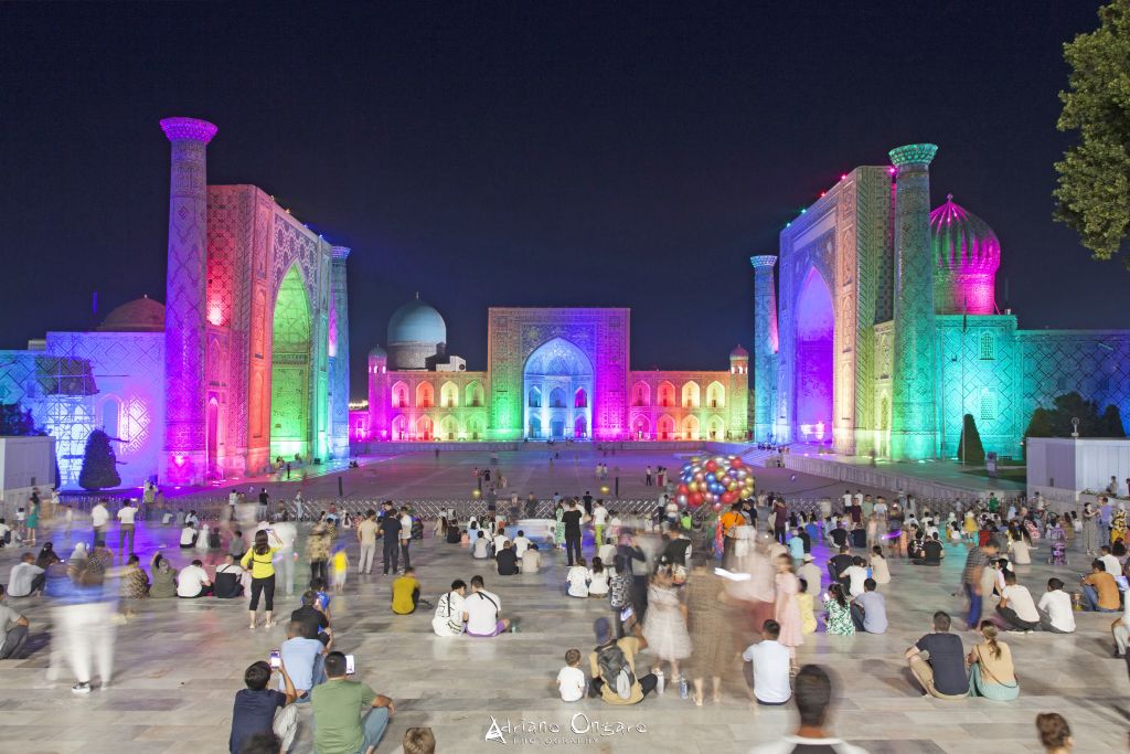 Spettacolo di luci serale tra le rovine illuminate del sito archeologico in Uzbekistan.