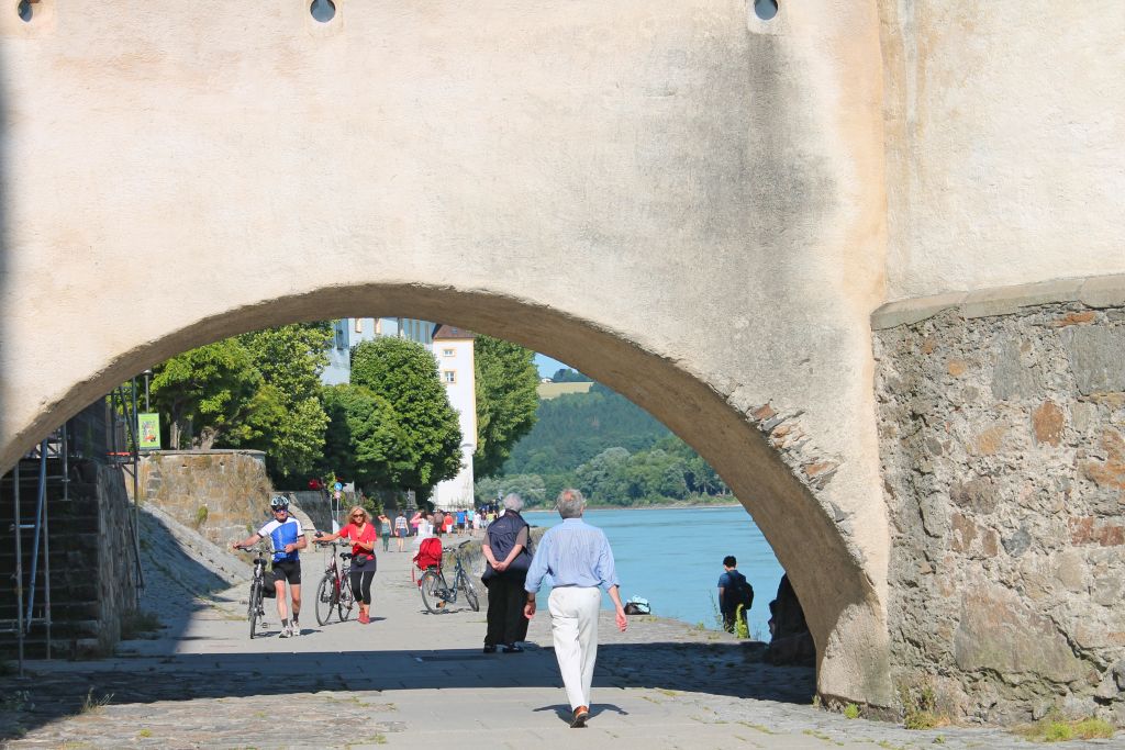 Ciclista attraversano un arco storico in una città lungo il percorso della Ciclabile del Danubio